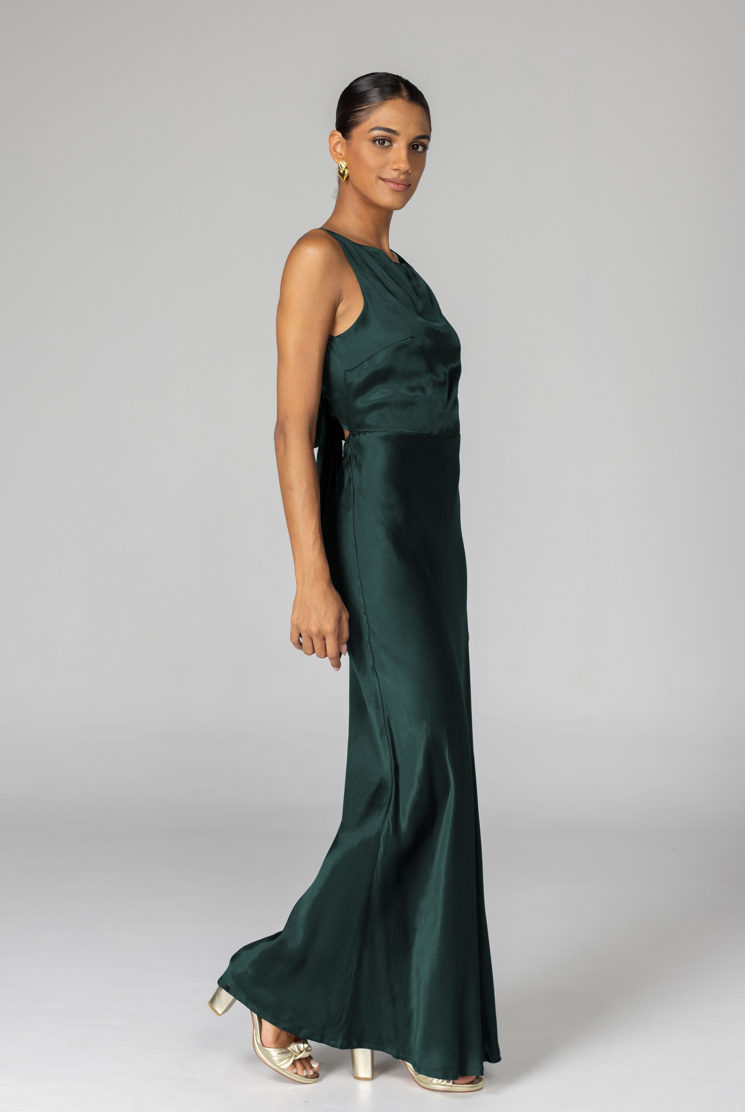 Woman wearing a green evening gown against a plain background
