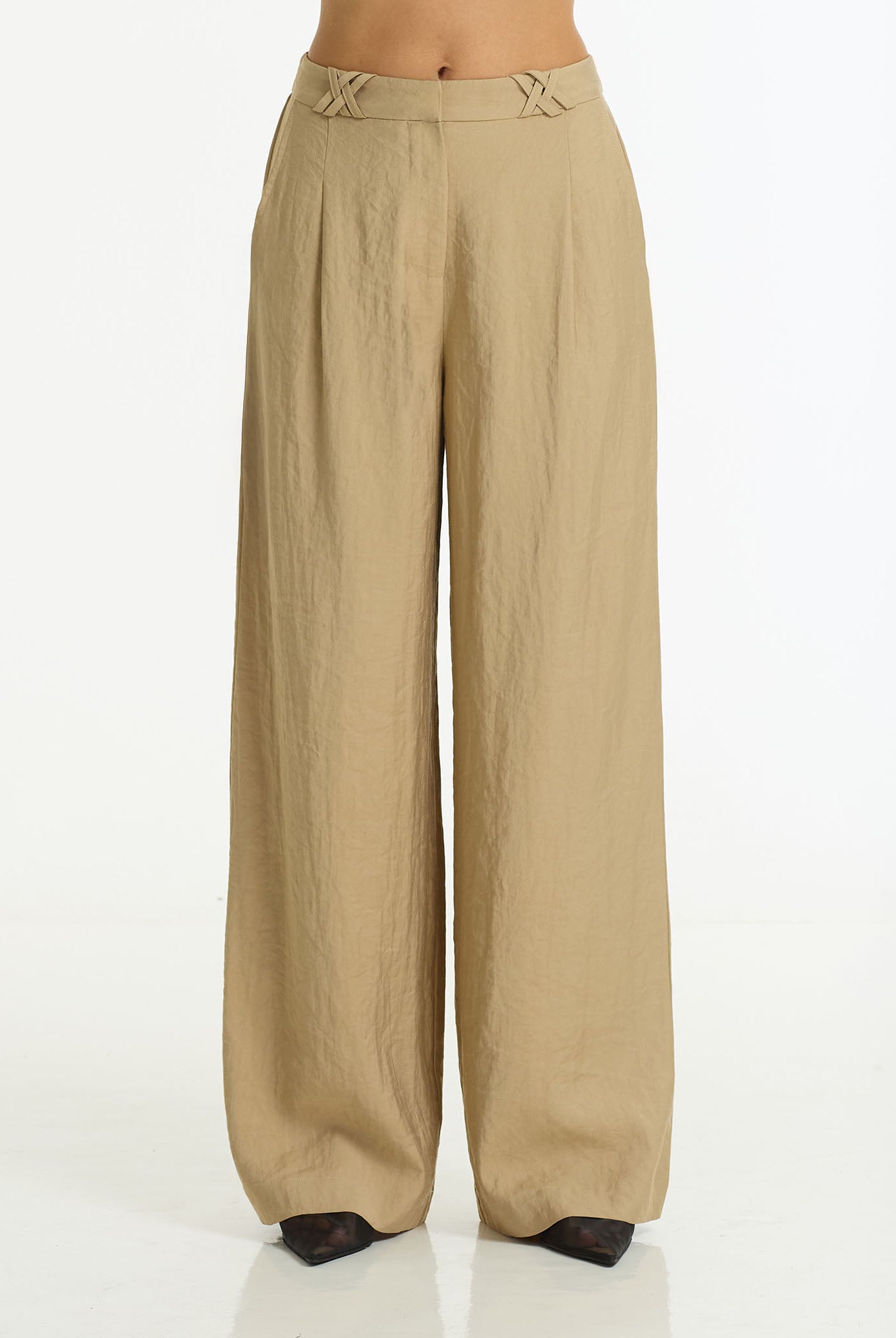 A pair of wide-leg, pleated trousers in a light tan or khaki color, shown on a model from the waist down against a plain white background.