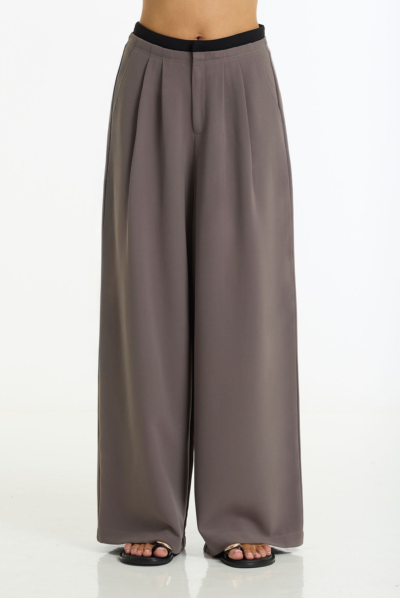 A model stands against a white studio background wearing the Marco Wide Leg Pant in charcoal / black by BLAK