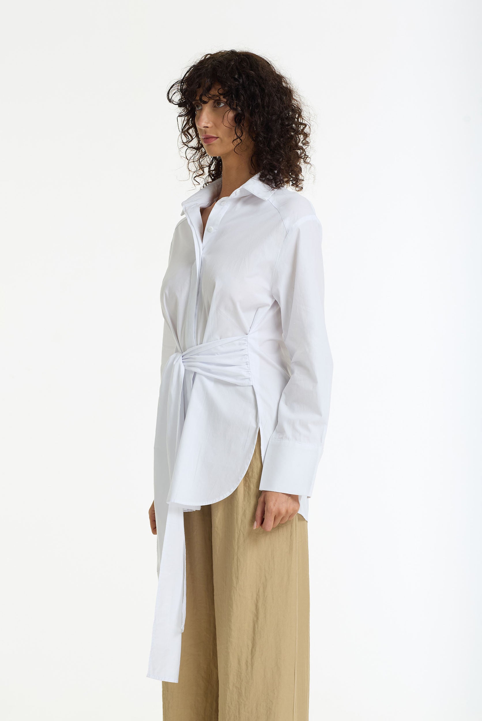 Side view of woman wearing Something About You Tie Waist Cotton Shirt in white by BLAK on a white background