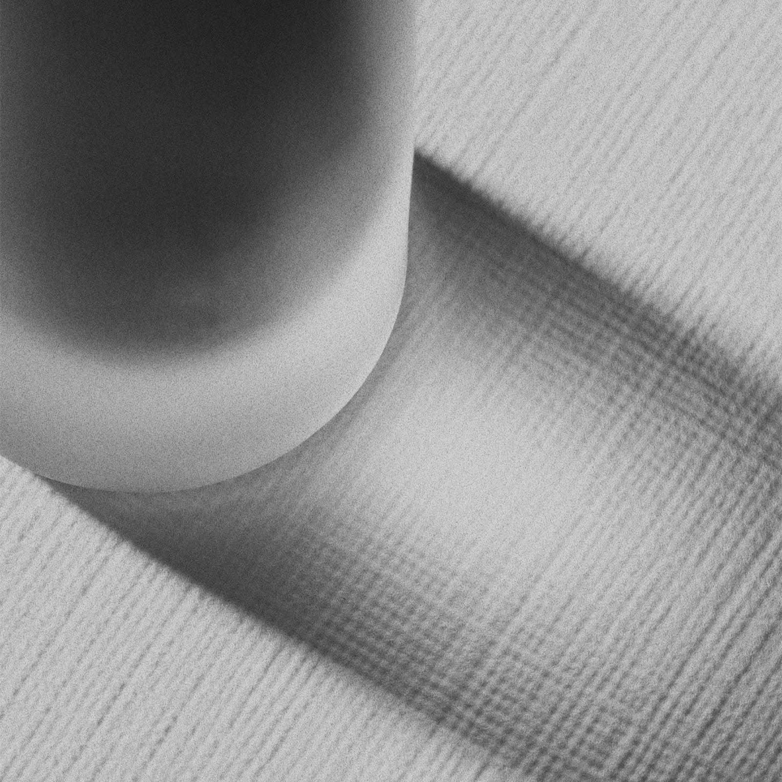 Close-up of Mascara botte shadow on a textured gray surface