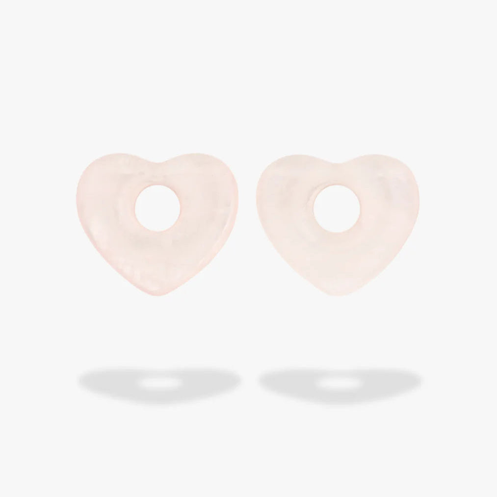 A pair of pale blush pink heart-shaped Rose Quartz Charm with a central hole, shown against a clean white background with soft shadows below.