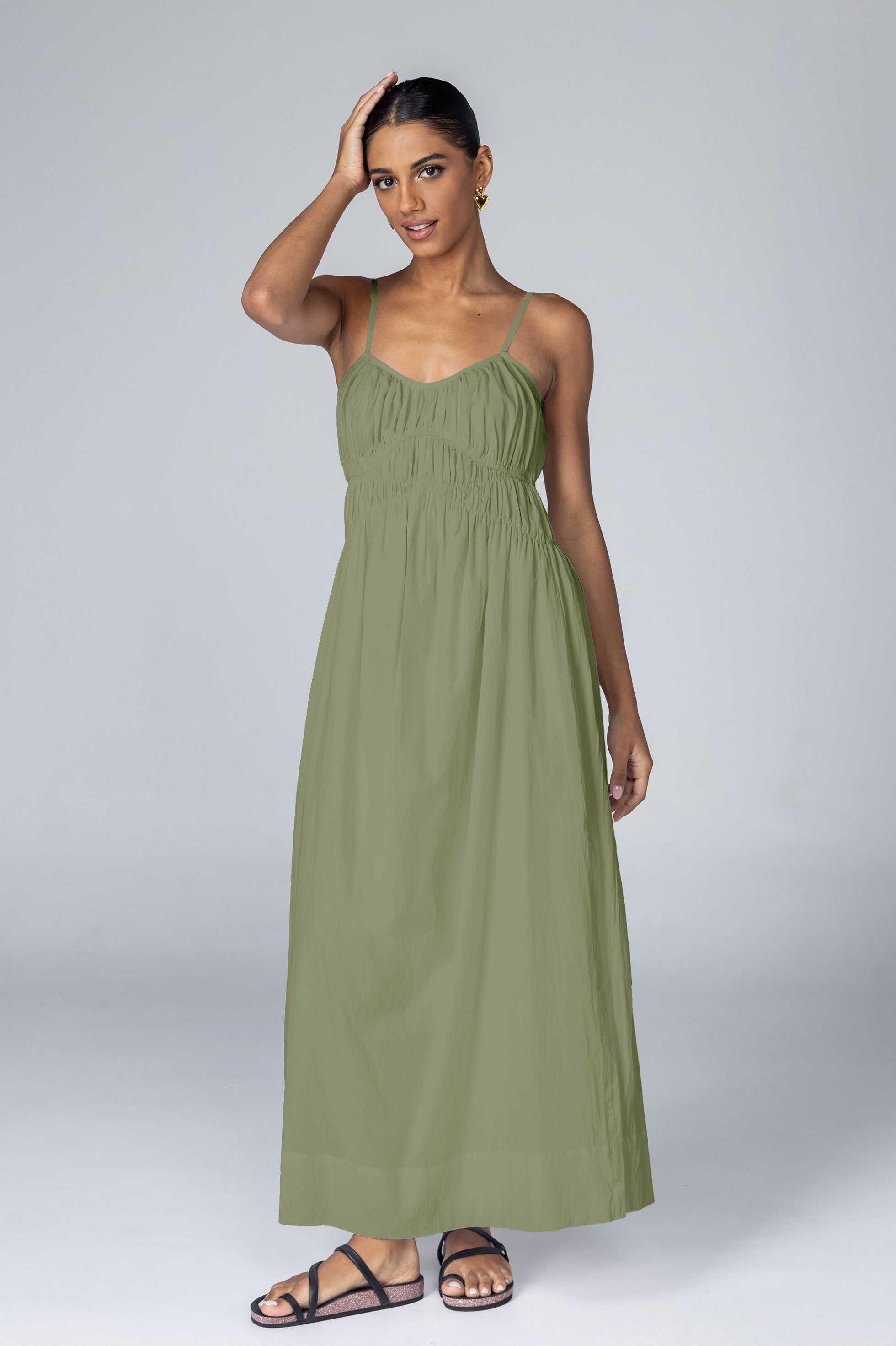 Woman wearing a green maxi dress against a plain background