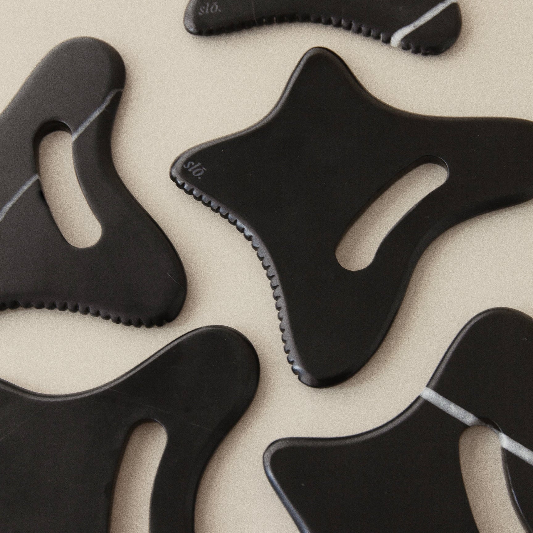 Black Gua Sha's on beige background