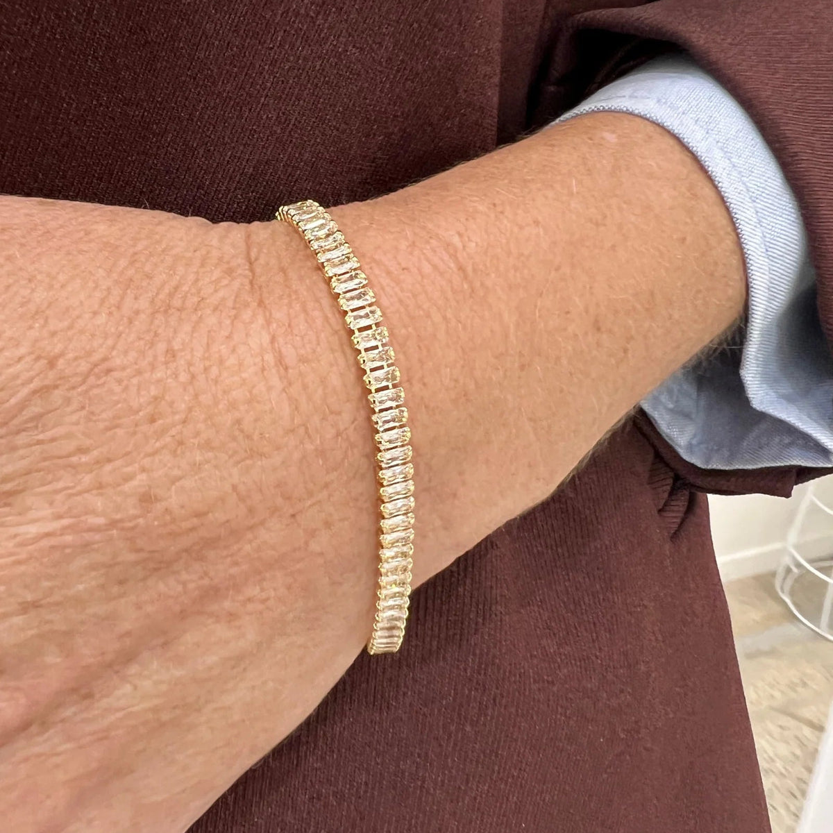 Gold bracelet on a wrist with a blurred background