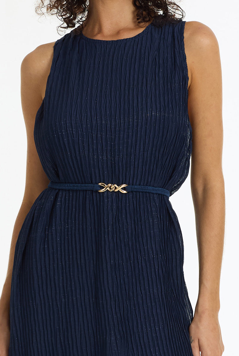 A sleeveless navy blue pleated dress with a matching waist belt featuring a gold-tone double-X buckle, shown on a model against a white background.